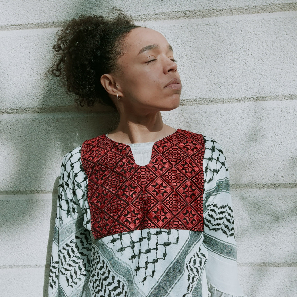 The traditional Keffiyeh redesigned as a comfortable and easy to wear poncho with traditional Palestinian Tatreez (embroidery), made in Hebron.