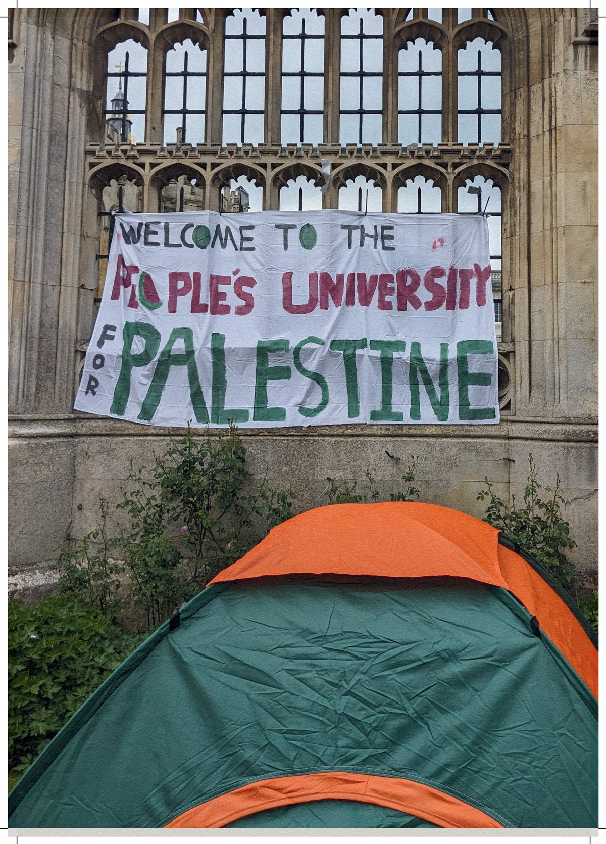 Protest setup with a banner reading 'Welcome to the People's University for Palestine' in front of a stone building.