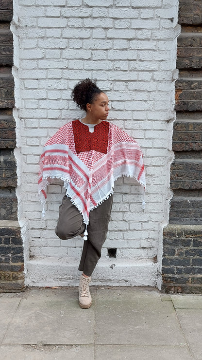 The traditional Keffiyeh redesigned as a comfortable and easy to wear poncho with traditional Palestinian Tatreez (embroidery), made in Hebron.